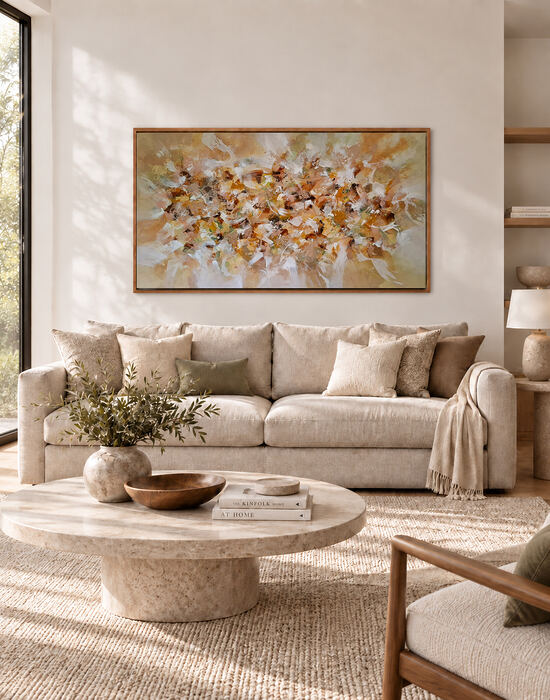 Quadro abstrato com moldura de madeira e pinceladas em tons terrosos, bege e branco, decorando a parede acima de um sofá claro em uma sala de estar contemporânea, com mesa de centro em pedra natural e iluminação suave.